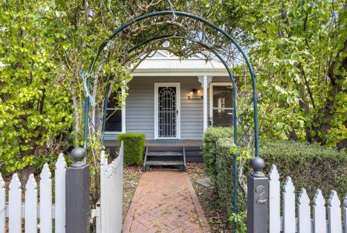 a white fence with a gate in front of a house at Birdie Daylesford in Daylesford