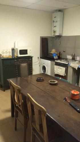 a kitchen with a wooden table with two chairs at Los Alamos in Gualeguay