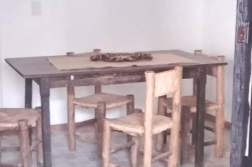 a wooden table with some chairs and a table with at Departamento para 4 personas. in Maipú