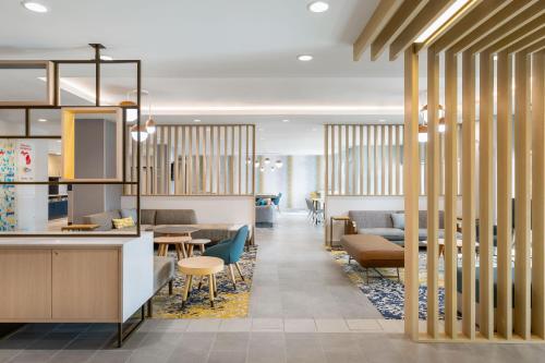 a lobby with tables and chairs and a cafeteria at TownePlace Suites by Marriott Iron Mountain in Iron Mountain