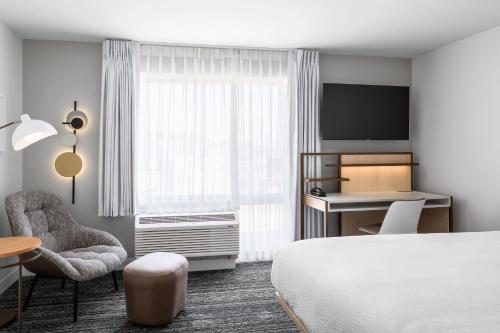 a hotel room with a bed and a desk and chair at TownePlace Suites by Marriott Iron Mountain in Iron Mountain