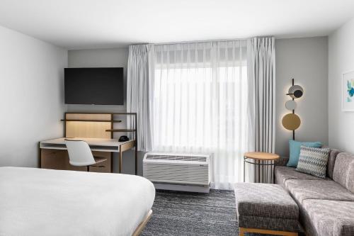 Habitación de hotel con cama y sofá en TownePlace Suites by Marriott Iron Mountain, en Iron Mountain