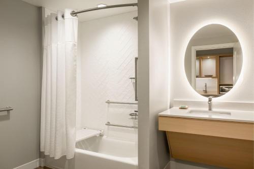 TownePlace Suites by Marriott Iron Mountain في أيرون ماونتين: حمام مع حوض ومغسلة ومرآة