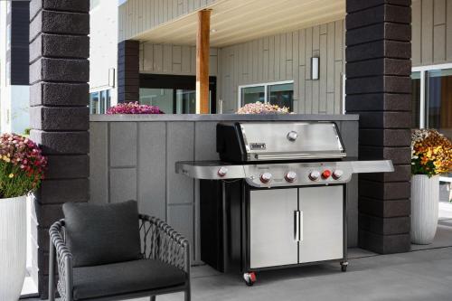 a barbecue grill and a chair on a patio at TownePlace Suites by Marriott Iron Mountain in Iron Mountain