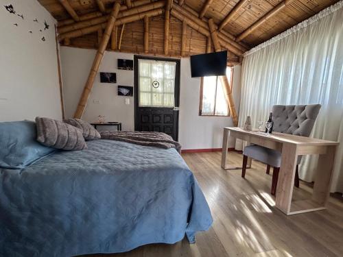a bedroom with a bed and a table and a desk at Quynza in Guatavita