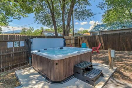 a hot tub in a yard next to a fence at Vibrant Watermelon - Hot Tub, BBQ-Grill, King-Bed, Backyard, Parking in Colorado Springs