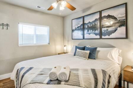 a bedroom with a bed with two towels on it at Vibrant Watermelon - Hot Tub, BBQ-Grill, King-Bed, Backyard, Parking in Colorado Springs