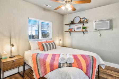 a bedroom with a bed and a ceiling fan at Vibrant Watermelon - Hot Tub, BBQ-Grill, King-Bed, Backyard, Parking in Colorado Springs