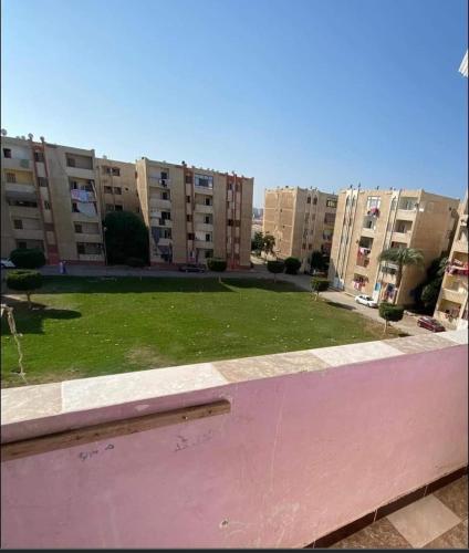 Blick auf einen Park mit Apartmentgebäuden im Hintergrund in der Unterkunft شقه الفردوس in Dumyat al Jadidah