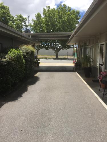 a driveway leading into a house with trees in the background at Central Wangaratta Motel in Wangaratta