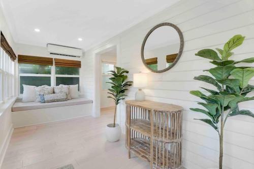 a living room with a mirror and a plant at Charming Cottage on Croton #1 in West Palm Beach