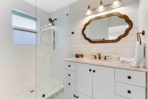 a bathroom with a shower and a sink and a mirror at Charming Cottage on Croton #1 in West Palm Beach