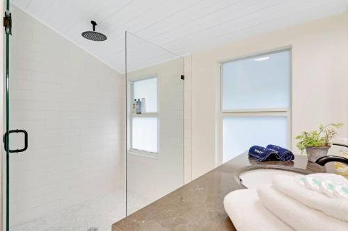 a bathroom with a glass shower and a sink at Cottage on Croton Way # 2 in West Palm Beach