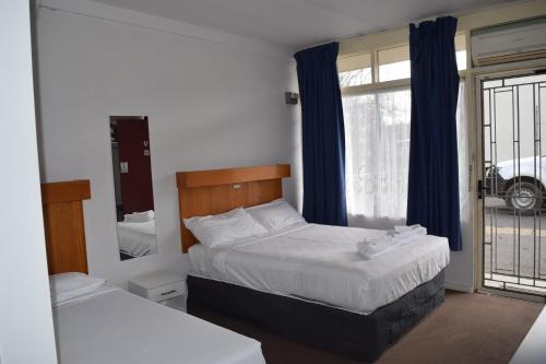 a bedroom with two beds and a window at Central Wangaratta Motel in Wangaratta