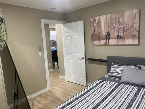 1 dormitorio con 1 cama y una pintura en la pared en Bellaire Midtown Cottage en Bellaire