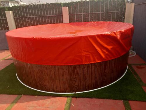 a large wooden tub with a red cover on it at Anc mall area east legon guest house in Accra