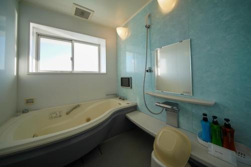 a bathroom with a tub and a toilet and a sink at ホテル ラヴィアン HOTEL Lavien 