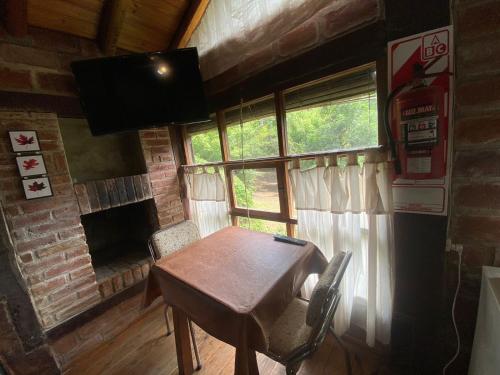 uma sala de jantar com uma mesa de madeira e uma lareira em Cabañas de madera 25 m2 Estilo Rústico em La Granja