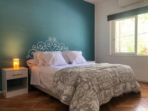 um quarto com uma cama com uma parede azul em CASA GRANDE em Mendoza