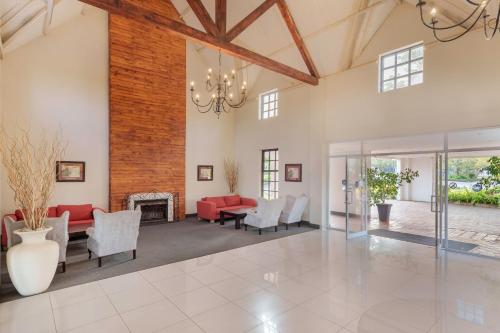 an open living room with a red couch and chairs at Protea Hotel by Marriott Chingola in Chingola