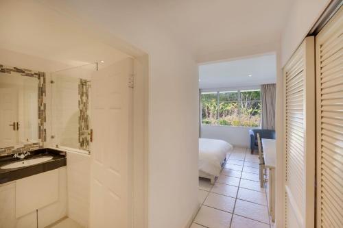ein Bad mit einem Waschbecken und ein Bett in einem Zimmer in der Unterkunft Protea Hotel by Marriott Chingola in Chingola