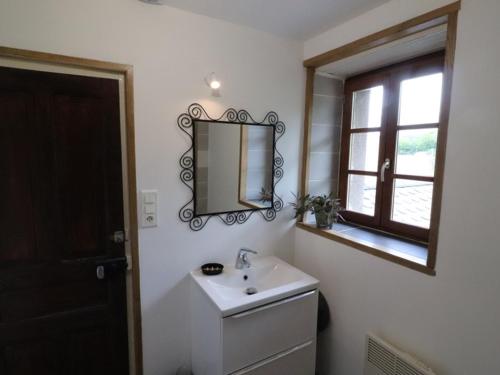 a bathroom with a sink and a mirror and a window at Gîte Vic-sur-Cère, 3 pièces, 4 personnes - FR-1-742-354 in Vic-sur-Cère