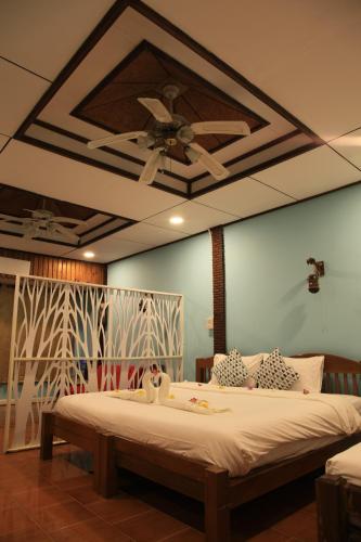 a bedroom with a bed with a ceiling fan at Koh Kood Cabana in Ban Lak Uan