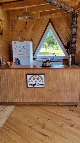 una cocina en una cabaña de madera con ventana en ANGEL DOMO, en Puerto Montt