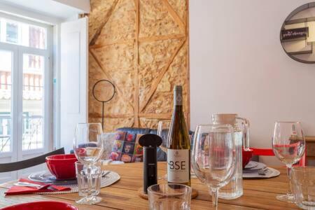 a wooden table with glasses and a bottle of wine at Old Town Chiado Balcony AirCon by LD Apartments in Lisbon
