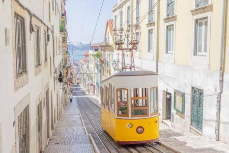 a yellow trolley car on a city street at Old Town Chiado Balcony AirCon by LD Apartments in Lisbon