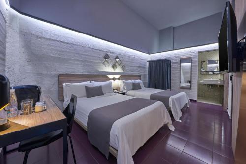 墨西哥城的住宿－City Centro by Marriott Ciudad de Mexico，一间酒店客房,设有两张床、一张桌子和一台电视机