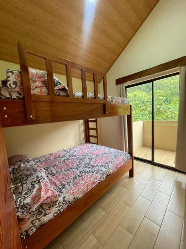 a bedroom with two bunk beds and a window at Casa Colibrí in Bijagua