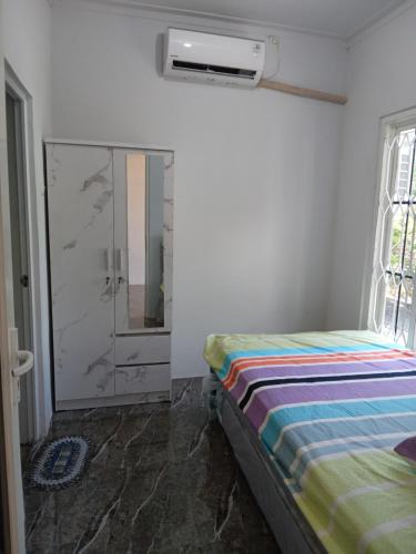 1 dormitorio con 1 cama y puerta de cristal en Siroen Homestay en Banyuwangi