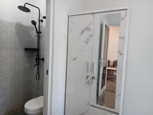 baño con ducha y puerta de cristal en Siroen Homestay en Banyuwangi