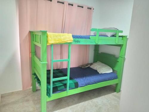 a green bunk bed in a room with a blue mattress at Cabañas Villa Rosita in Socorro