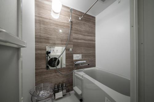 a bathroom with a tub and a mirror on the wall at ASCEND【2min from Asahikawa sta】 in Asahikawa
