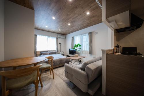 een woonkamer met een bank en een tafel bij ASCEND【2min from Asahikawa sta】 in Asahikawa