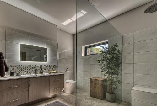 a bathroom with a shower and a sink and a mirror at SALT Luxury Couples Villa in Venus Bay