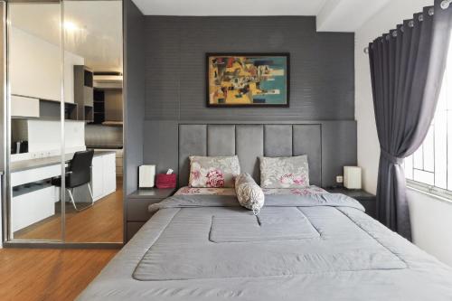 a bedroom with a large bed with gray walls at The Edge by Lia in Cimindi-hilir
