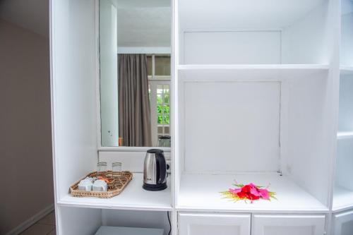 パシフィック・ハーバーにあるYatu Lau Lagoon Resort Fijiの白いキャビネットと鏡付きのキッチン