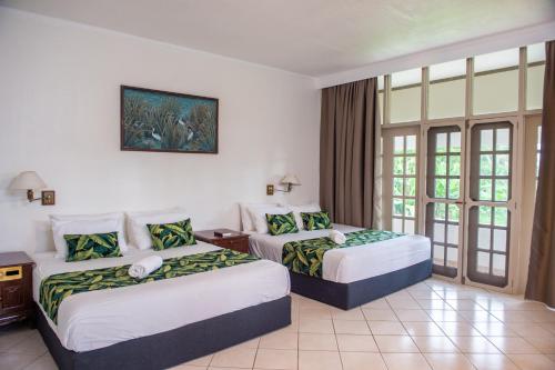 パシフィック・ハーバーにあるYatu Lau Lagoon Resort Fijiのベッド2台と窓が備わるホテルルームです。