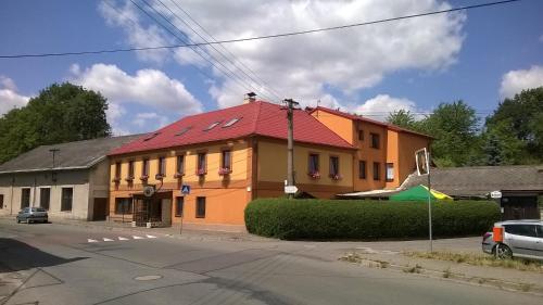 a building with a red roof on a street at Penzion U Slunce in Jaroměř