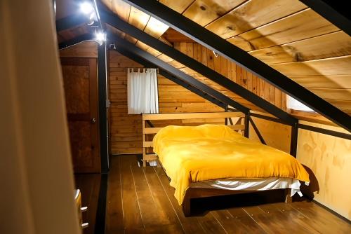 a bedroom with a yellow bed in a attic at Nuevo Tombstone in Valle de Bravo