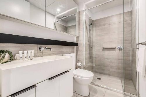 uma casa de banho branca com um WC e um chuveiro em Central & Stylish in St Kilda w AC, WiFi & Balcony em Melbourne