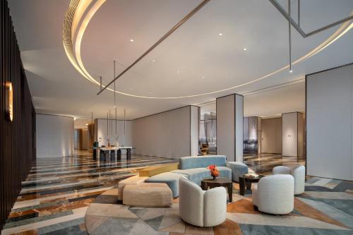 a lobby with a couch and chairs and a table at Hotel Indigo Wuxi Taihu New City in Wuxi