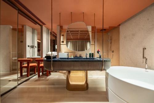 a bathroom with a tub and a large mirror at Hotel Indigo Wuxi Taihu New City in Wuxi