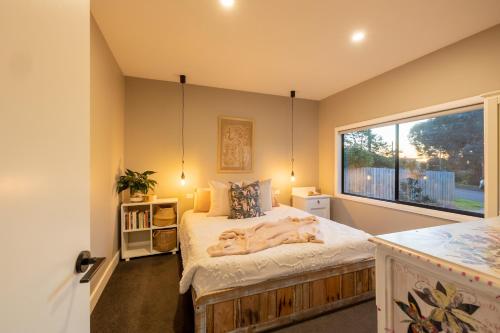 a bedroom with a bed with a large window at Jujube in Dromana