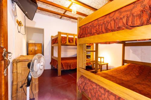 a bedroom with two bunk beds and a fan at Mamaqocha in Canoas de Punta Sal