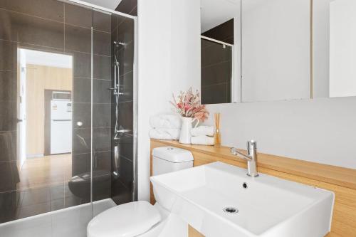 een badkamer met een wastafel, een toilet en een douche bij Modern 2BR Apt Next to Southern Cross FREE Parking in Melbourne