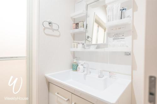 y baño con lavabo blanco y espejo. en WeeklyHouse Silto Crete - Vacation STAY 14148v en Otsu